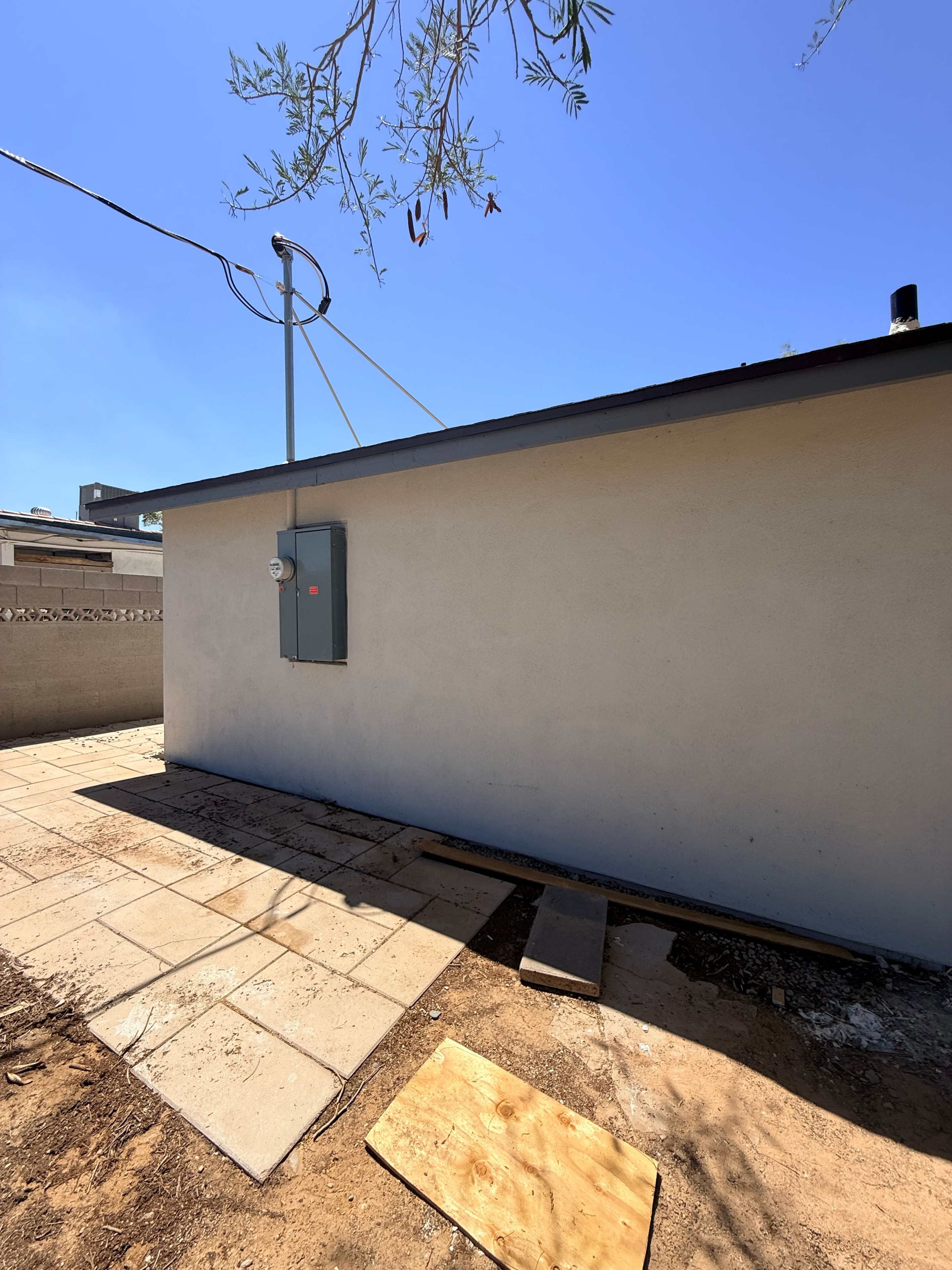 Exterior stucco restoration with new electrical panel installation