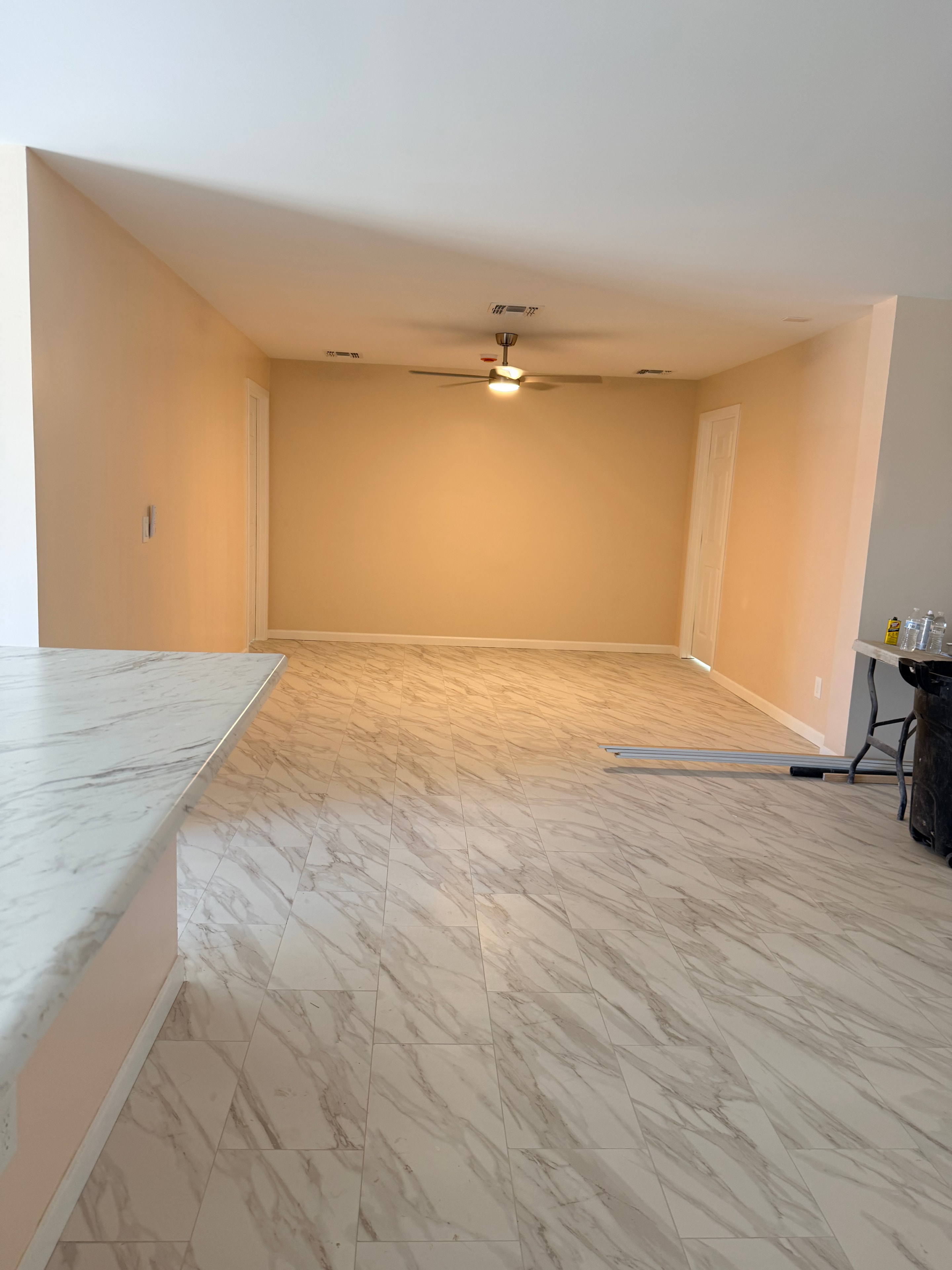 Renovated interior hallway with marble tile accent wall and warm lighting
