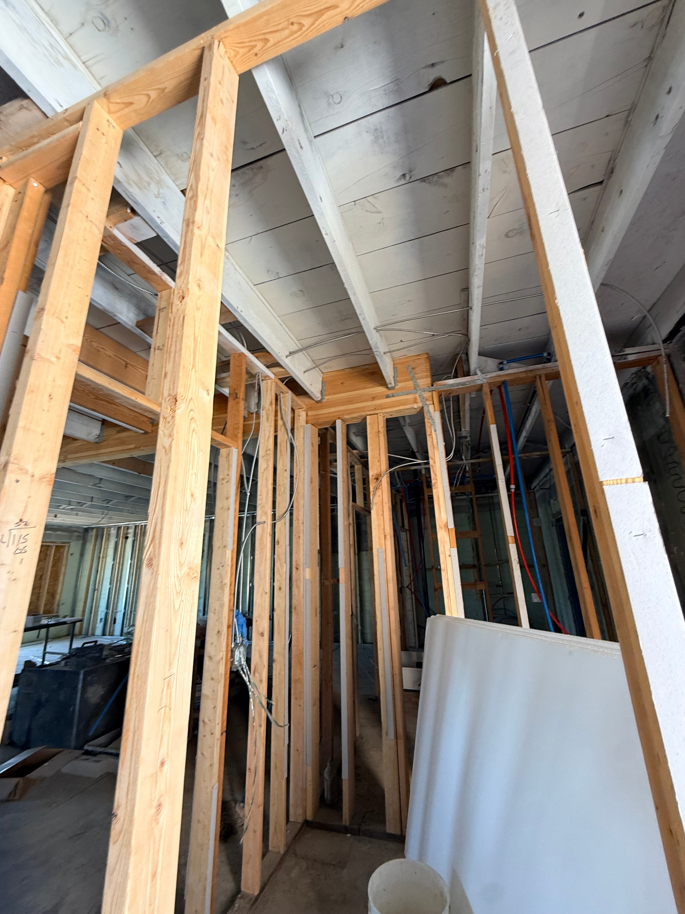 Interior staircase framing with exposed lumber joists and plumbing rough-in