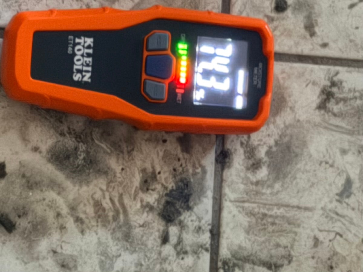 Orange stud finder detecting wall studs — RMSERVCORP precision restoration